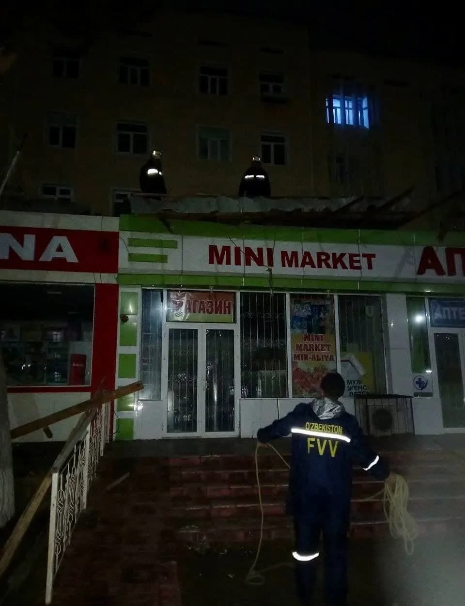 Тунги вақтда ФВВ ходимлари дўкон устига қулаган том бўлакларини тозаламоқда
