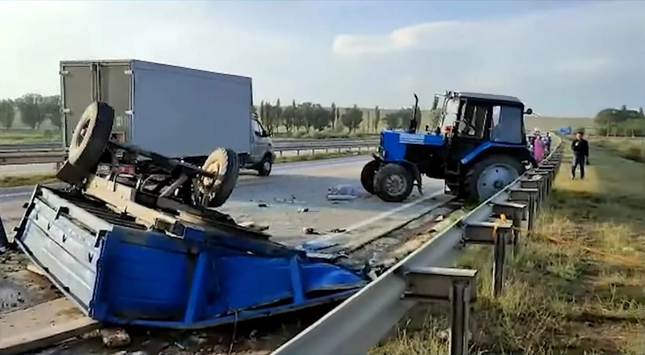 Йўл ўртасида ағдарилган кўк рангли юк машинаси ва трактор