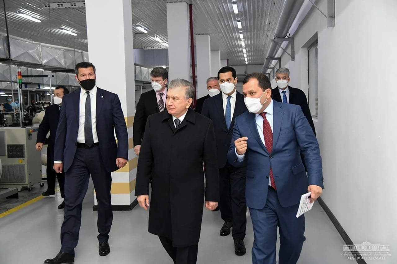 Shavkat Mirziyoyev hamrohlar bilan sanoat korxonasi binosi ichida ketmoqda