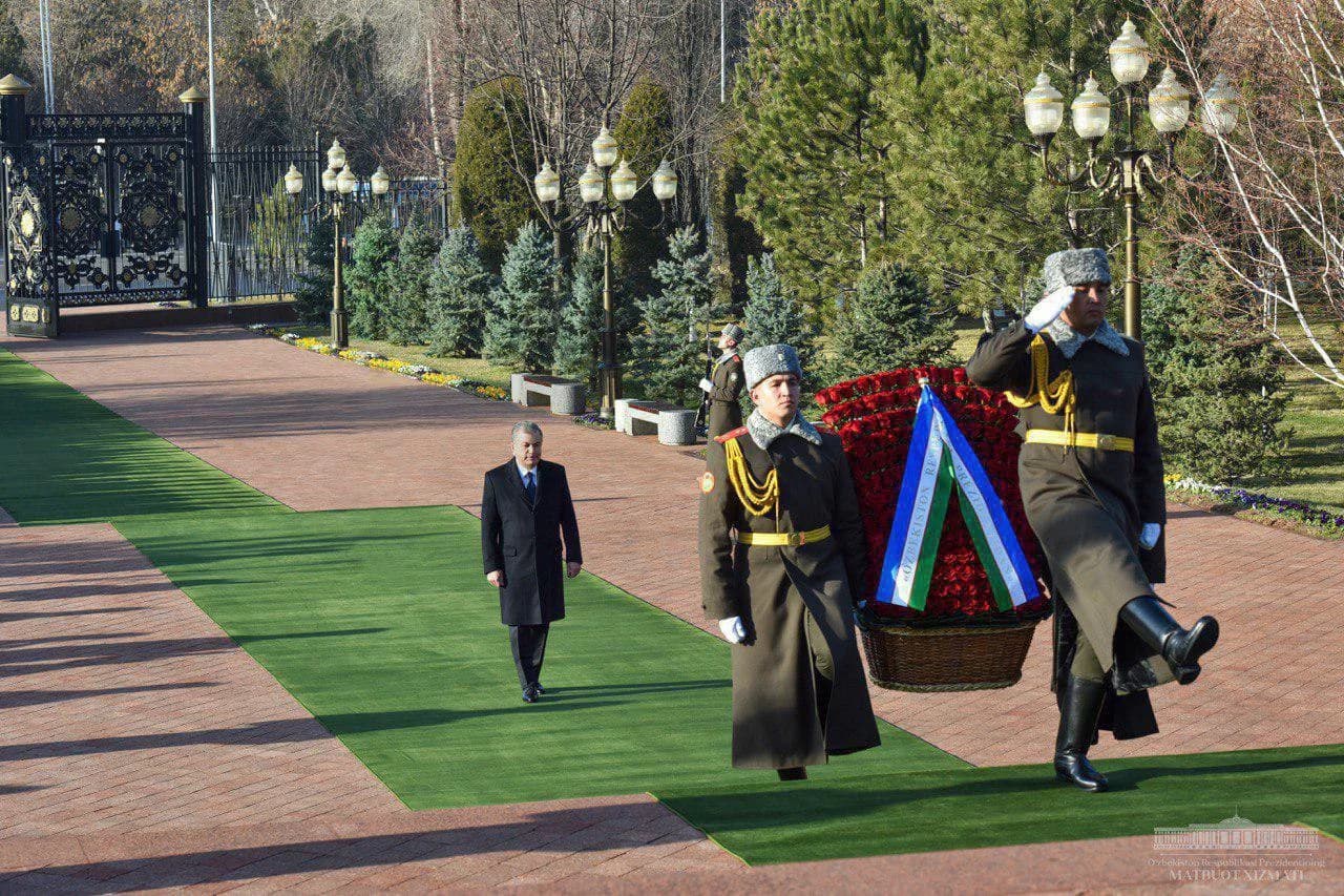 Фахрий қоровул аскарлари гулчамбар кўтариб бормоқда, орқада Шавкат Мирзиёев