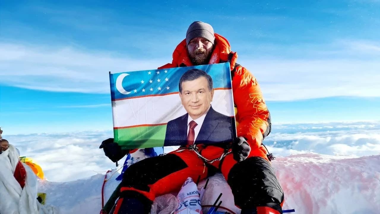 Сергей Денисенко Эверест чўққисида Шавкат Мирзиёев сурати туширилган байроқни ушлаб турибди