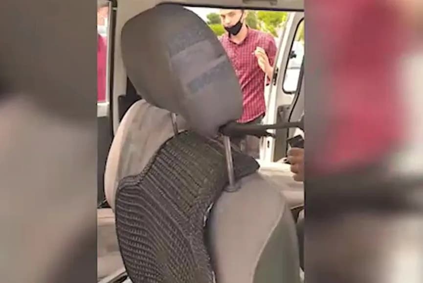 Автомобиль ичидан олинган видеолавҳадан лавҳа: ташқарида ниқоб таққан эркак турибди