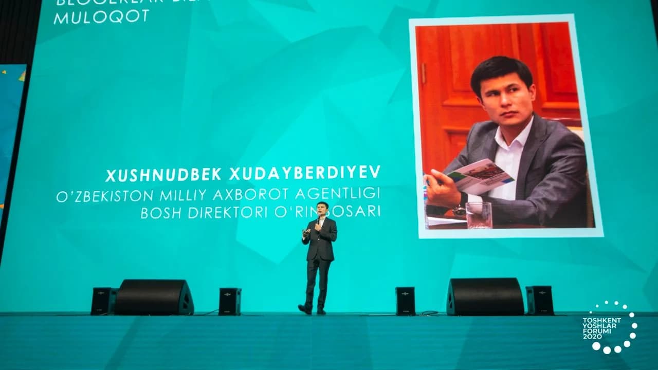 Katta ekranda Xushnudbek Xudoyberdiyevning ismi va lavozimi yozilgan tasvir