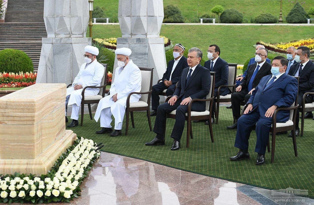 Prezident va diniy ulamolar ramziy qabr yonida o'tiribdi